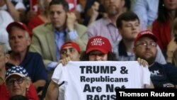 A supporter reacts by showing a T-shirt as U.S. President Donald Trump speaks during a campaign rally in Cincinnati, Aug. 1, 2019. 