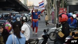 Thai-German national David Pfizenmaier walks through a traffic intersection holding a sign encouraging Thais to vote in the upcoming election in Bangkok on March 21, 2019.