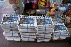 FILE - Copies of the final edition of Apple Daily are seen at a newsstand in Hong Kong, June 24, 2021.