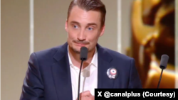 پی‌یر لوتن، بازیگر فرانسوی - روی کت او یک پین با کلمه ایران بود. عکس از «کانال+» تلویزیون فرانسوی