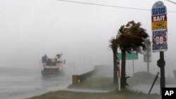 Sebuah truk melintasi jalan Hwy 24 saat angin kencang yang dipicu badai Florence menghembus pepohonan palem di Swansboro, North Carolina, 13 September 2018.