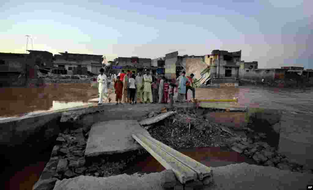 Residents examine a portion of bridge damaged by flooding on the outskirts of Islamabad, Pakistan, Sept. 6, 2014.