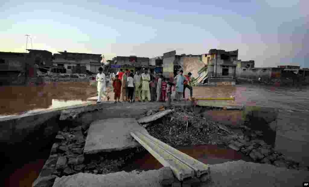 Warga memeriksa bagian jembatan yang rusak akibat banjir di pinggiran Islamabad, Pakistan, 6 September 2014.