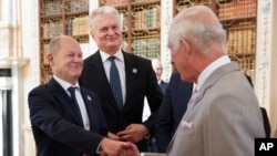 Britain's King Charles shakes hands with German Chancellor Olaf Scholz next to Lithuanian President Gitanas Nauseda during the European Political Community meeting, near Oxford, England, on July 18, 2024.