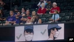 Una pantalla en el Globe Life Field, en Arlington, Texas, recuerda la forma correcta de usar una máscara durante un partido de béisbol, el 3 de agosto de 2021. 