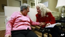 File - Alexis McKenzie, right, executive director of The Methodist Home of the District of Columbia Forest Side, an Alzheimer's assisted-living facility, shares a light moment with resident Catherine Peake, in Washington, February 6, 2012.