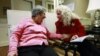 Alexis McKenzie, right, executive director of The Methodist Home of the District of Columbia Forest Side, an Alzheimer's assisted-living facility, shares a light moment with resident Catherine Peake, in Washington, February 6, 2012.