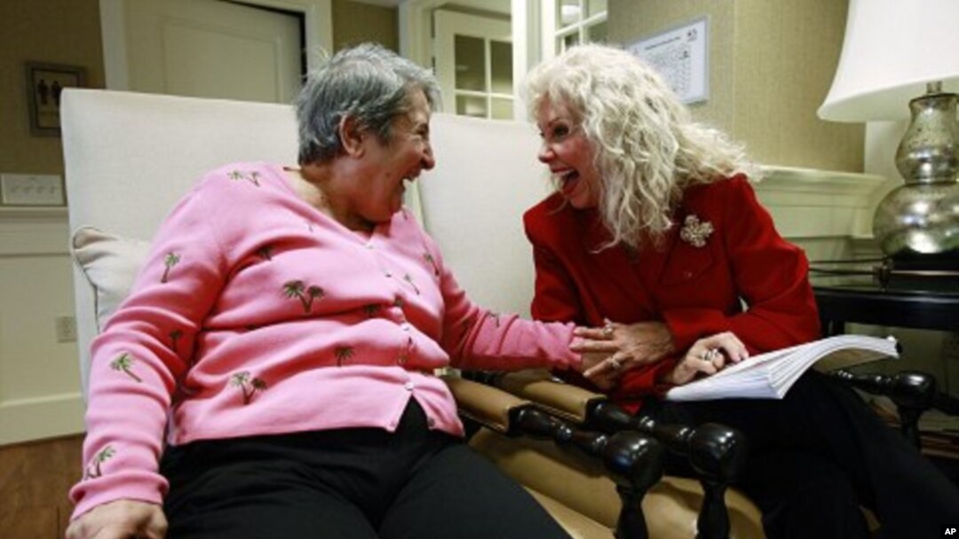 File - Alexis McKenzie, right, executive director of The Methodist Home of the District of Columbia Forest Side, an Alzheimer's assisted-living facility, shares a light moment with resident Catherine Peake, in Washington, February 6, 2012.