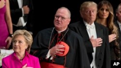 Hillary Clinton et Donald Trump, avec le cardinal de New York Timothy Dolan, lors d'un dîner caritatif de gala organisée par la fondation Alfred E. Smith dans le Waldorf Astoria à Manhattan, New York, jeudi 20 octobre 2016.