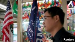 FILE - A flag of the U.S. President Donald Trump's "Keep America Great!" 2020 re-election campaign and the U.S. flag are seen in a flag stall at the Yiwu Wholesale Market in Yiwu, Zhejiang province, China, May 10, 2019. 