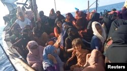 FILE - A boat carrying Rohingya refugees, including women and children, is seen stranded in waters off the coast of Bireuen, Aceh province, Indonesia, Dec. 27, 2021, in this still image taken from a video.