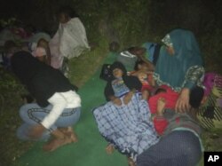 Warga tidur di tanah setelah meninggalkan rumah mereka untuk mencari tempat yang lebih tinggi setelah gempa bumi di Gane Utara, Maluku Utara, Minggu, 14 Juli 2019.