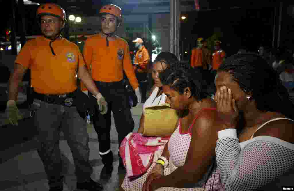 Rescue team members and patients react outside a clinic that was evacuated after tremors were felt resulting from an earthquake in Ecuador, in Cali, April 16, 2016.
