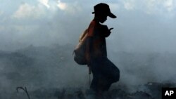 Fumée provenant de la combustion de déchets, à la périphérie de Phnom Penh, Cambodge 