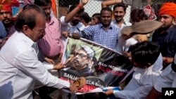 Members of India's Rajput community beat with sandals a poster of film director Sanjay Leela Bhansali as they protest against the release of Bollywood film "Padmavati" in Hyderabad, India, Nov. 21, 2017. 