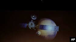 A rendering of the Schiaparelli Space Module and of the planet Mars is displayed on a movie screen, during an event on the occasion of the insertion of the Trace Gas Orbiter into orbit around Mars, and landing of the Schiaparelli module on the surface of the planet, in Rome, Oct. 19, 2016. 