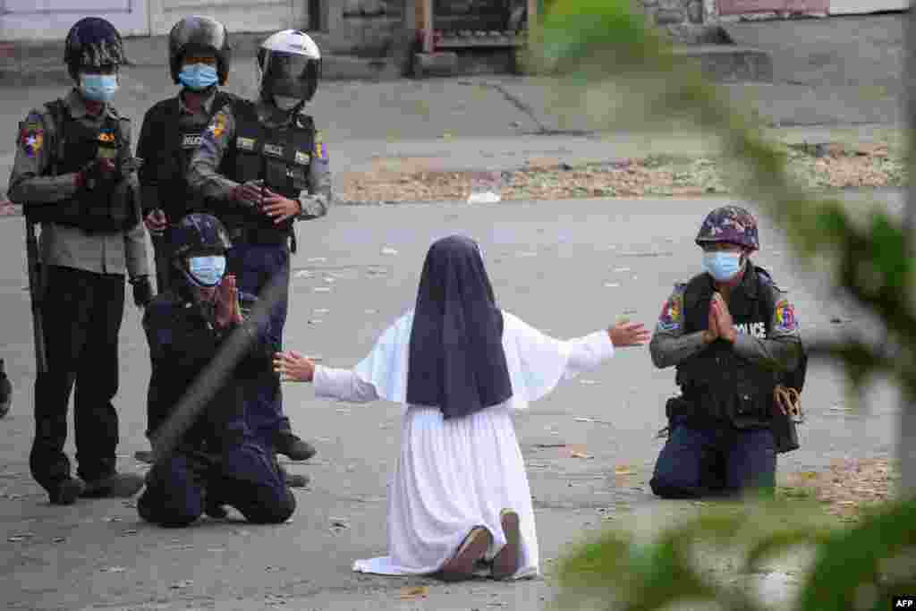 This handout photo by the Myitkyina News Journal shows a nun pleading with police not to harm protesters in Myitkyina, in Myanmar&#39;s Kachin state, March 8, 2021.
