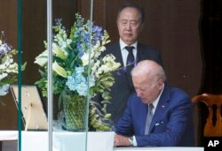 조 바이든 미국 대통령(오른쪽)이 8일 아베 신조 전 일본 총리의 빈소가 마련된 주미일본대사관저를 찾아 조문했다. 왼쪽은 도미타 코지 주미일본대사.