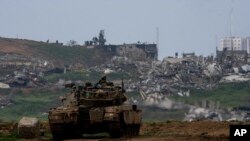 FILE — Israeli soldiers drive a tank on the border with Gaza Strip, as seen from southern Israel, March 19, 2024.