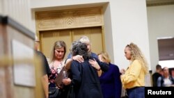 Relatives of the victims of the Ghost Ship warehouse fire embrace after a jury failed to convict master tenant Derick Almena and acquitted Max Harris of involuntary manslaughter that killed 36 people in 2016, in Oakland, Calif., Sept. 5, 2019.