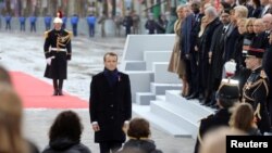 French President Emmanuel Macron pays his respects by the Tomb of the Unknown Soldier during a commemoration ceremony for Armistice Day, 100 years after the end of the World War I, at the Arc de Triomphe, in Paris, Nov. 11, 2018. 