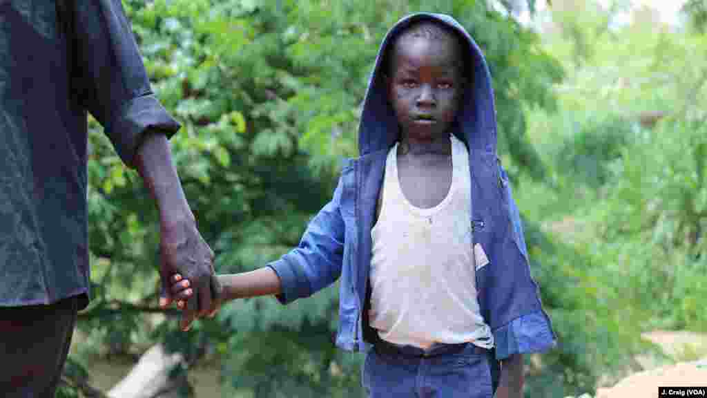 John Wesley, 7 ans, traverse la frontière entre le Soudan du Sud et l'Ouganda avec son père, le 1er avril 2017.