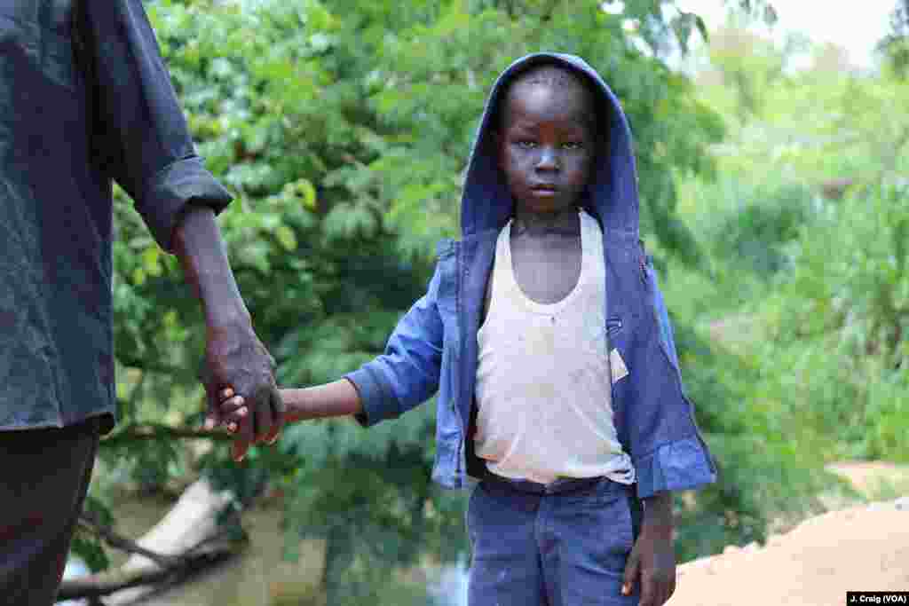 Seven-year-old John Wesley slowly crosses the border from South Sudan into Uganda with his father at the Busia border point on April 1 in Koboko, Uganda.