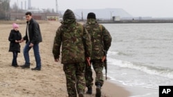 While most of the unrest between Ukrainian forces and pro-Russian separatists are concentrated in the rebel-held areas of Donetsk, local volunteers patrol the city beach in Mariupol, Donetsk region of Ukraine, March 14, 2015. 