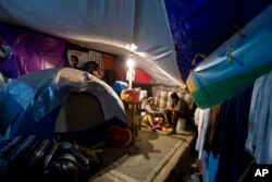 Axel Lopez Martinez, 18, helps 13-year-old neighbor Juan Alfredo Cuaclayo Rodriguez with his homework inside one of the tent camps where residents of earthquake-damaged Independencia 18 have been living, in Mexico City, March 14, 2018.