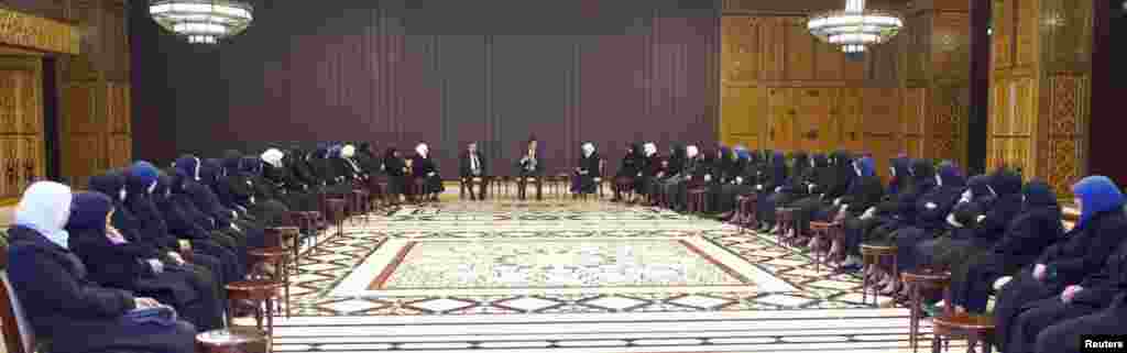 This SANA photo shows Syrian President Bashar al-Assad speaking to female preachers from mosques in Damascus and its countryside and educators of religious high schools and institutes in Damascus, Jan. 14, 2014.