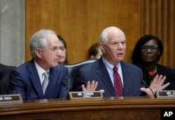FILE - Senate Foreign Relations Committee Chairman Bob Corker, left, listens as Sen. Ben Cardin speaks during a committee business meeting on the nomination of Rex Tillerson to be secretary of state, Jan. 23, 2017 in Washington.