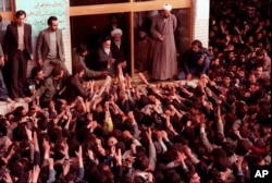 FILE - Ayatollah Ruhollah Khomeini, center, is greeted by supporters in Tehran, Iran, Feb. 2, 1979.