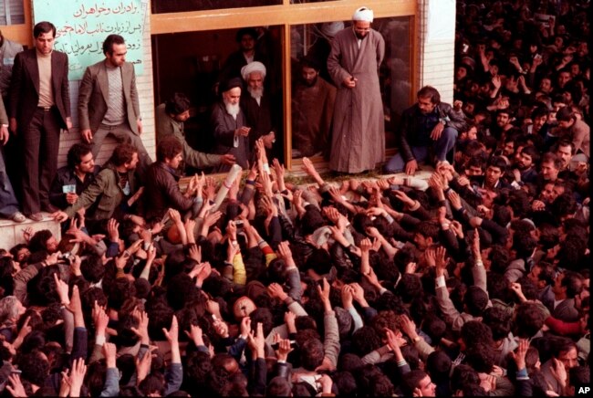 FILE - Ayatollah Ruhollah Khomeini, center, is greeted by supporters in Tehran, Iran, Feb. 2, 1979.