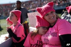 Zoe Rodis (8 tahun)bersandar pada ibunya, Jennifer Rodis (kanan) dalam pawai "Women's March" di Las Vegas, 21 Januari 2018.