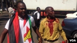 Itai Dzamara with an injured member of Tajamuka-Sesijikile Campaign after they were forced to flee by the police.