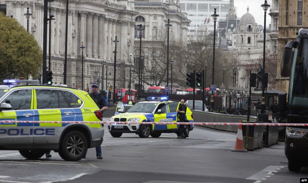 Armed police officers stand guard inside a security cordon, outside of the Houses of Parliament in central London on March 22, 2017 during an emergency incident.