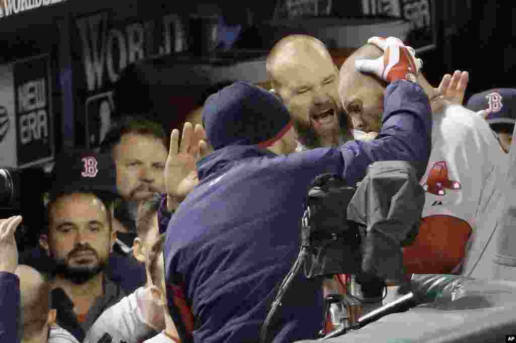 Boston Red Sox's Jonny Gomes is congratulated in the dugout after hitting a three-run home run during the sixth inning of Game 4 of baseball's World Series against the St. Louis Cardinals Sunday, Oct. 27, 2013, in St. Louis. (AP Photo/David J. Phillip)