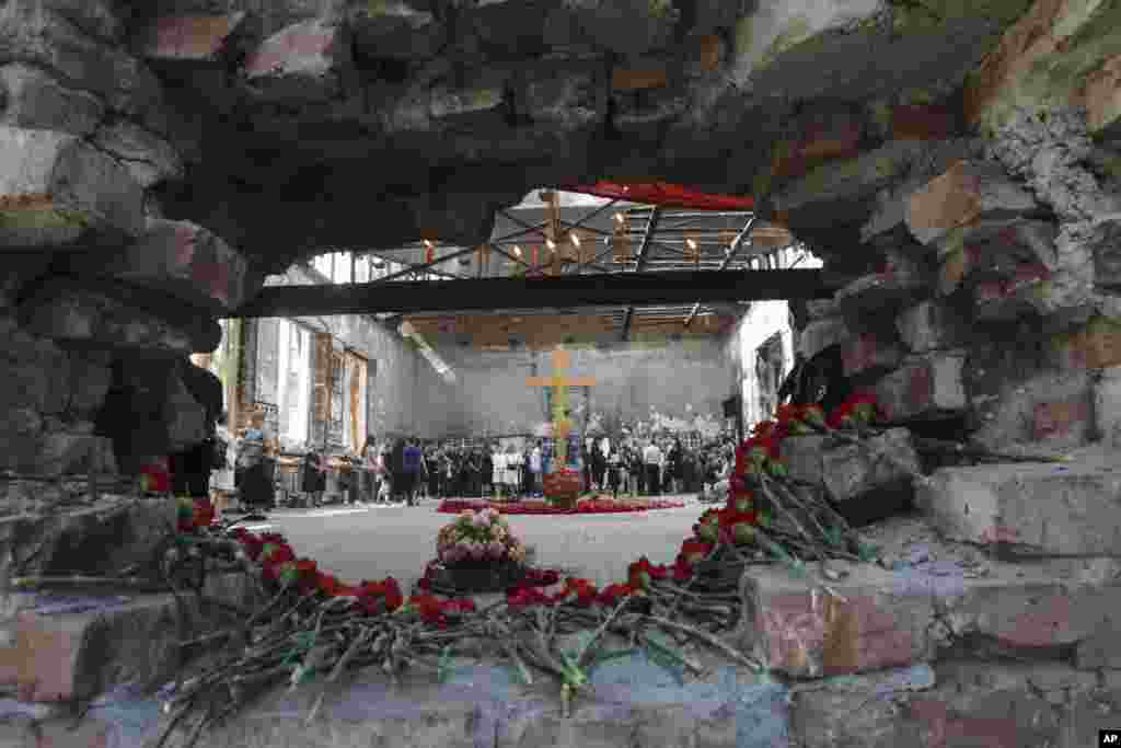 Flowers are laid in a hole in a wall as people gather in the gym of a school - the scene of the hostage crisis - in memory of victims on the 15th anniversary of the tragedy in Beslan, North Ossetia region, Russia.