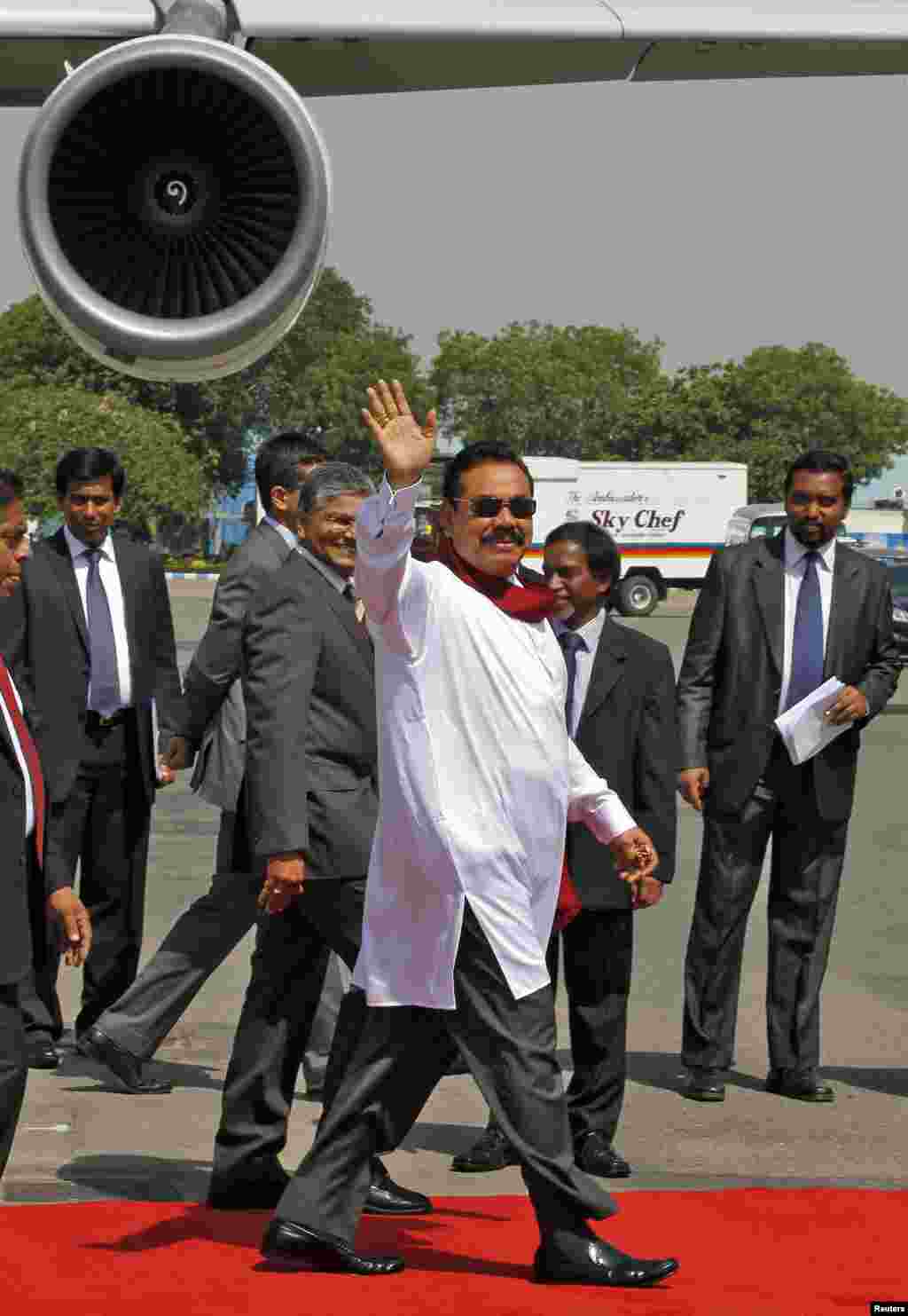 Sri Lanka's President Mahinda Rajapaksa waves upon his arrival at the airport in New Delhi, May 26, 2014. 