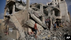 FILE - Yemeni men inspect a house destroyed by a Saudi-led airstrike in Sanaa, Yemen, Monday, Jan. 25, 2016. 