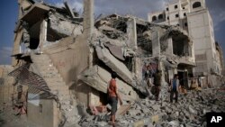 FILE - Yemeni men inspect a house destroyed by a Saudi-led airstrike in Sanaa, Yemen, Monday, Jan. 25, 2016. 