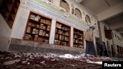 A Houthi militant walks inside the mosque after a suicide bomb attack in Sana'a, Yemen, March 20, 2015.