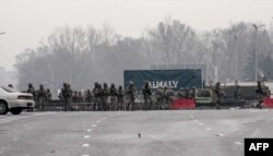 Servicemen block a street in central Almaty, Jan. 7, 2022, after violence that erupted following protests over hikes in fuel prices.