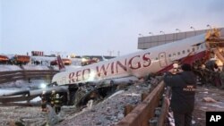 Petugas penyelamat di tempat kecelakaan pesawat di Bandar Udara Vnukovo, Moskow (29/12). (AP/Alexander Usoltsev)