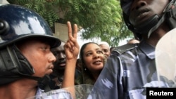 FILE - Lubna Hussein (C), a former journalist and U.N. press officer, gestures outside the court after her trial in Sudan's capital Khartoum, August 4, 2009.