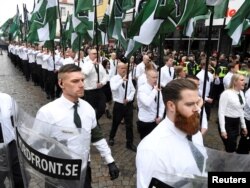 FILE - Members of the Neo-nazi Nordic Resistance Movement march through the town of Ludvika, Sweden, May 1, 2018. The march was opposed by anti-fascist groups, and the local police, reinforced from other parts of Sweden, kept the groups apart.