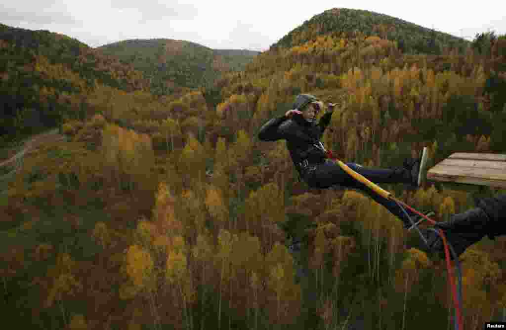 A woman rope jumps from a 44-meter-high (144-feet-high) waterpipe bridge in the Siberian Taiga area outside Krasnoyarsk, Russia. 