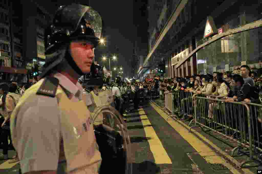 Riot police stand guard against protesters at a pro-democracy protest encampment in the Mong Kok district of Hong Kong early Sunday, Oct. 19, 2014.