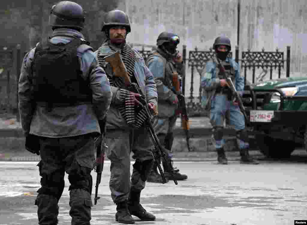 Afghan policemen stand at the site of a suicide attack in Kabul, Feb. 26, 2015.