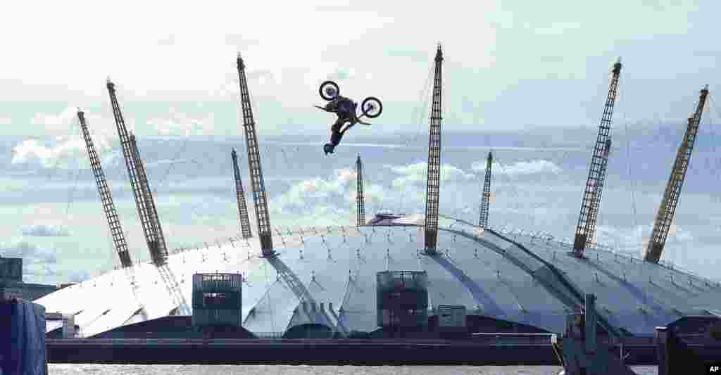 Nitro Circus ringleader and stunt professional Travis Pastrana performs the first motorcycle backflip over the River Thames with a 75-foot wide gap between two floating barges, with the Millennium dome in the background , in London.